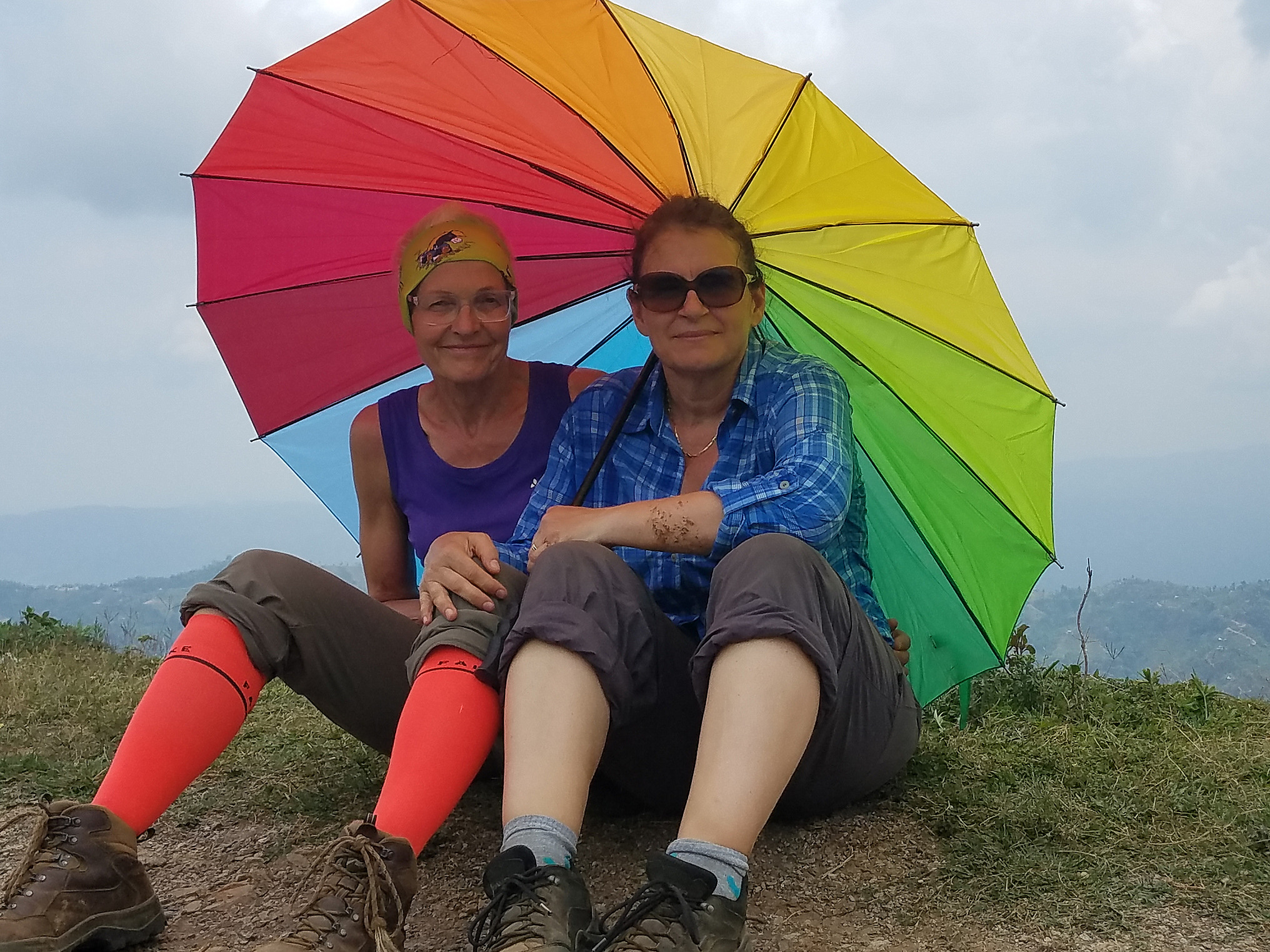 Dr. Gänslen-Blumber und Bärbel Bauder im Himalaya unter einem bunten Regenschirm.